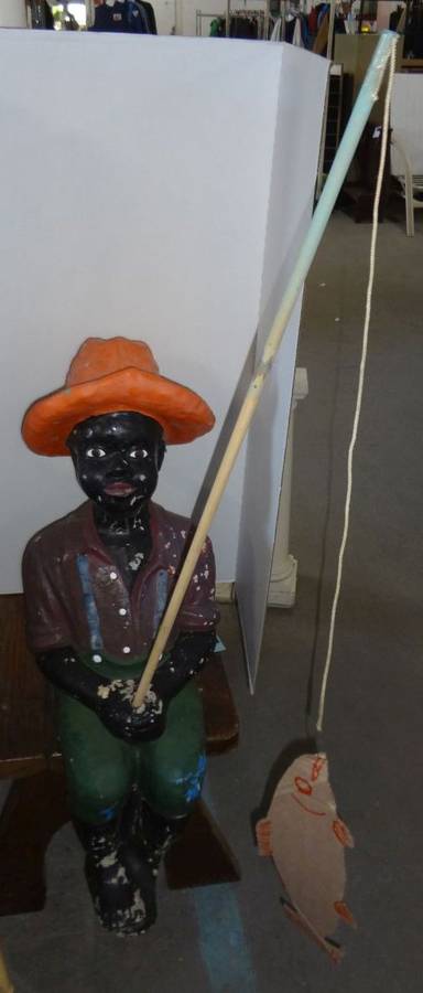 [Painted wooden statue depicting an African American man holding a fishing  pole]